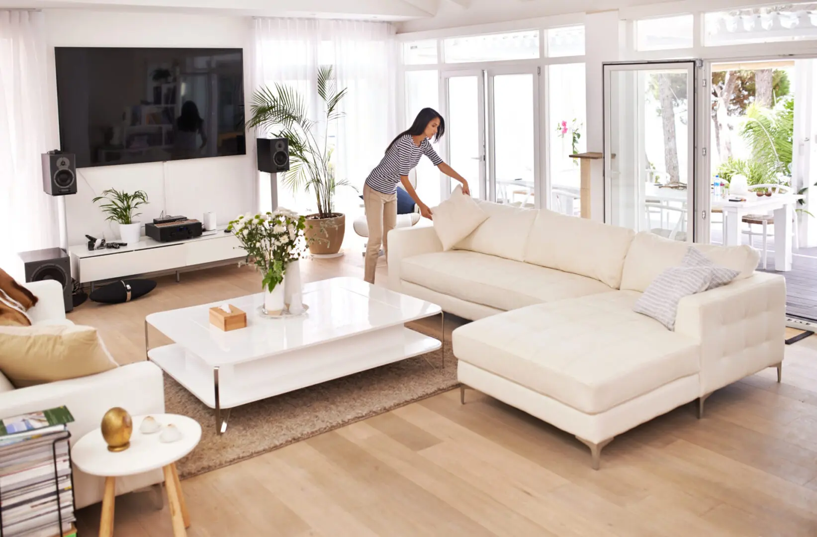 Woman tidying a modern living room.