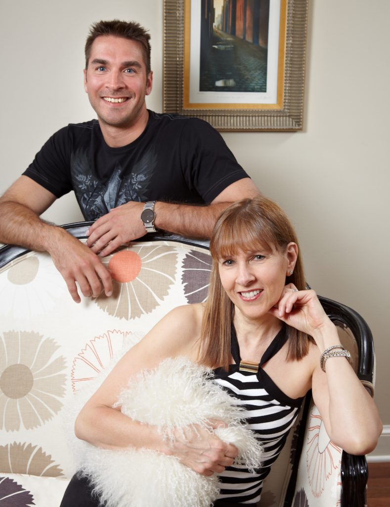 A man and woman sitting on top of a chair.